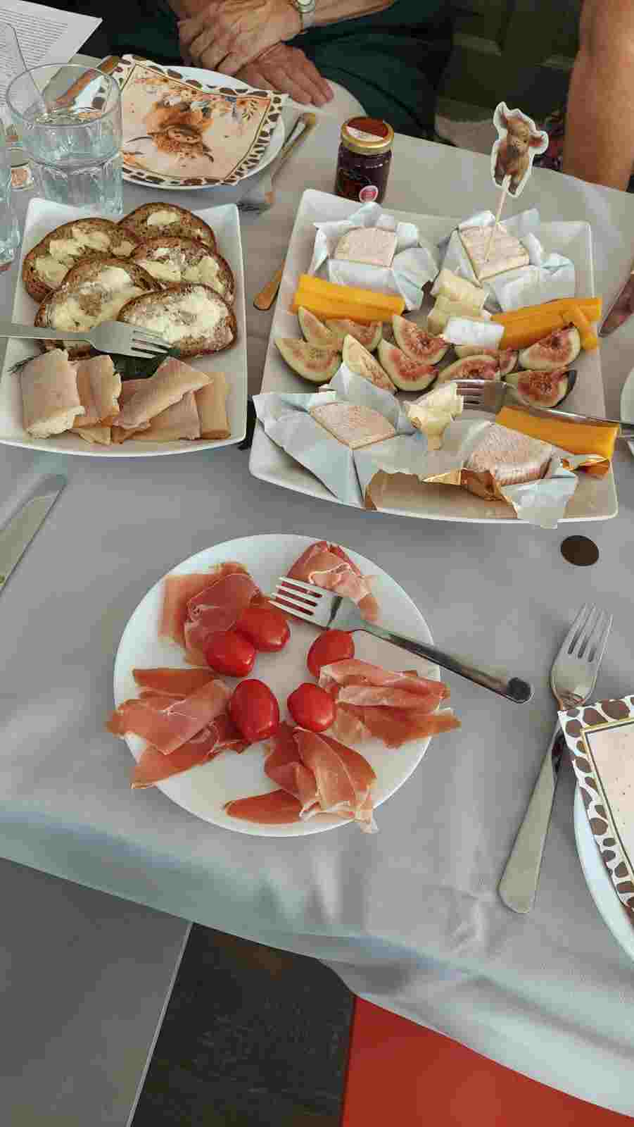 Ortsgemeinschaft Brühl-Ost. Einladung zum Whisky Tasting Ein Tisch mit mehreren Tellern, belegt mit Schinken, Käse und frischen Tomaten.