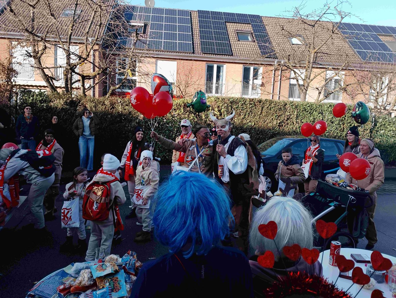 Team Kahramanlar - Karnevalszug in Brühl-Ost 2026 Menschen in Karnevalskostümen feiern mit roten Luftballons auf der Straße.